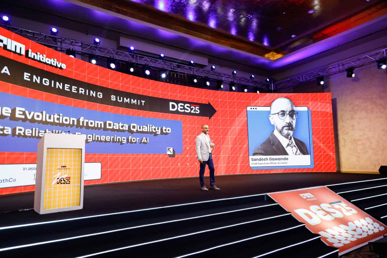 Data Engineering Summit 2026 stage with speaker and large screen display.